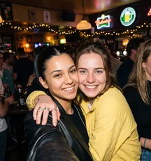Twee vriendinnen maken een selfie aan de bar.
